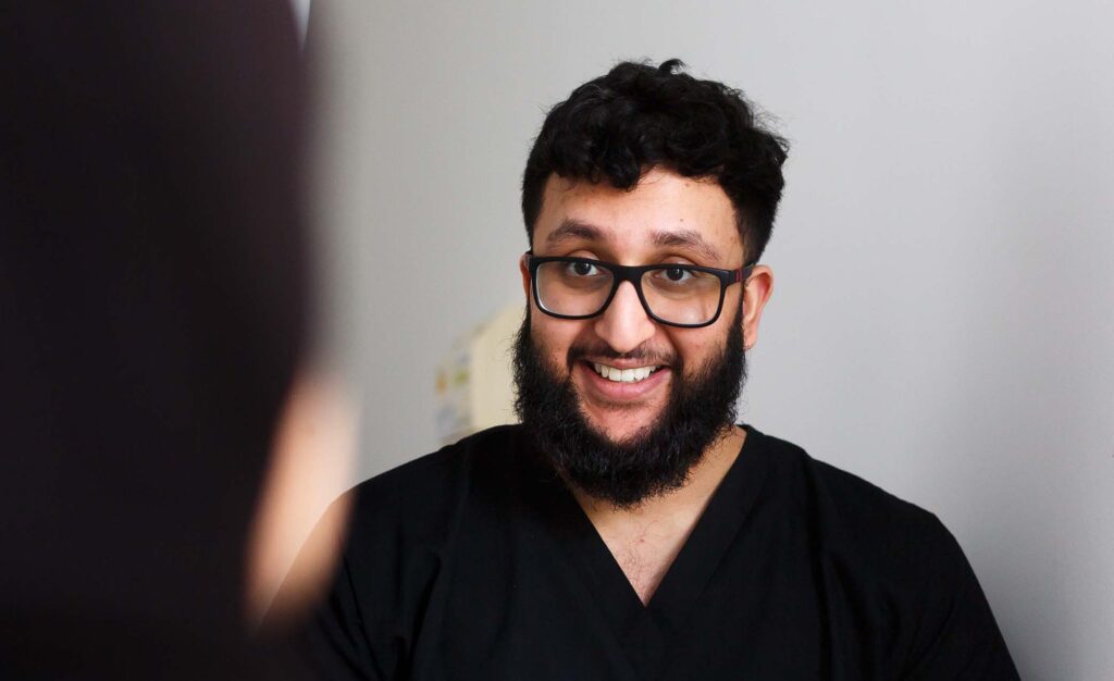 Photo of Dr. Junaid Khalil speaking to patient, Skipton Road Dental, Colne